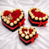 Heart-shaped gift boxes with red roses and gold-wrapped chocolates