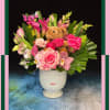 Pink floral arrangement with a teddy bear in a white vase