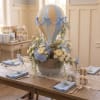 A charming custom baby shower centerpiece designed with Candlelight garden roses, white