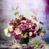 Mixed pink, purple, and white flowers arranged in a black vase