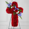 Red floral cross on a black stand with blue and white accents