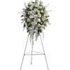 White floral standing spray on an easel with ribbon streamers