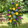 Tall standing floral spray with yellow, blue, purple, and pink blooms