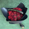 Bouquet of red roses wrapped in black paper with a birthday ribbon