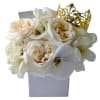 White roses and orchids in a lavender box with a gold crown topper