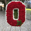 Red and white floral standing tribute shaped like a letter O