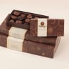 Stacked boxes of assorted chocolates with one open tray