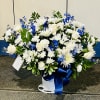 White roses and chrysanthemums with blue flowers in a white vase