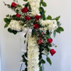 Cross-shaped floral tribute with red roses and white chrysanthemums