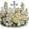 White floral arrangement with roses and stock around a silver cross