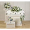 White casket with blue and white floral sprays