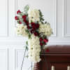 A large, dignified tribute cross designed for a funeral setting, this flower