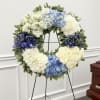 A cool-toned, full-bodied funeral wreath that reads as serene and respectful-the perfect