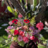Mixed pink and red flower arrangement with roses and anemones