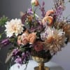 Peach and cream floral arrangement in a gold vase