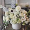 White and blush floral arrangement in a white vase