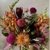 Colorful mixed flower arrangement in a gold vase