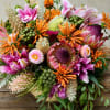 Colorful bouquet with pink lilies, orange blooms, and purple flowers