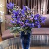 Purple iris bouquet in a blue glass vase