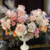 Bouquet of pastel roses in a white pedestal vase