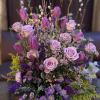 Lavender roses and purple tulips in a round vase with mixed filler flowers