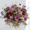 Bouquet of purple and burgundy flowers in a clear glass vase