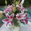 Pink and white lilies arranged in a striped vase
