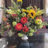 Large mixed bouquet with sunflowers, dahlias, and snapdragons in a white vase