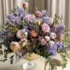 Pastel bouquet of roses and hydrangeas in a pedestal vase