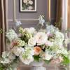 Pastel floral arrangement in a stone pedestal vase