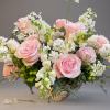 Pink roses and white flowers arranged in a low vase