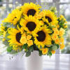 Bouquet of yellow sunflowers and small yellow roses in a white vase