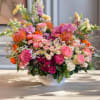 Large mixed flower arrangement in a white bowl vase