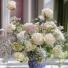 White roses and pale blooms in a blue vase