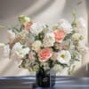Large bouquet of white and blush flowers in a black vase