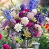 Colorful mixed bouquet in a clear vase with blue, purple, pink, and white blooms