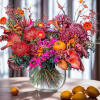 Colorful bouquet of orange, pink, and purple flowers in a glass vase
