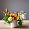 Tropical floral arrangement in a white vase with orange and white blooms