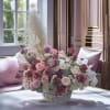 Large pink and white rose arrangement in a woven basket with pampas grass