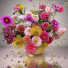 Pink and yellow mixed flower arrangement in a low vase