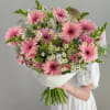 Soft pink gerbera daisies take center stage in this large hand-tied bouquet