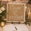 Guest book sign beside white roses and lanterns