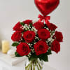 Red roses in a glass vase with a red heart balloon