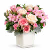 Pink and white rose bouquet in a square glass vase