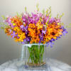 Bright orange, purple, and pink orchid arrangement in a clear vase