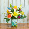 Mixed bouquet with lilies, carnations, and daisies in a painted glass vase