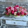 Pink and red rose arrangement in a white bowl vase