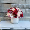 Bouquet of red and blush roses in a white vase