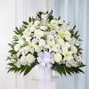 White floral standing spray with lilies, roses, and chrysanthemums on a pedestal