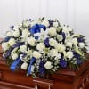 White and blue funeral spray on a casket with ribbon